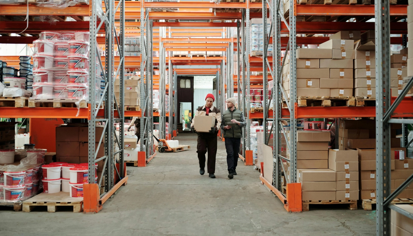Two hourly-paid warehouse shift workers checking stock together, illustrating UK pay rights for shift and hourly workers
